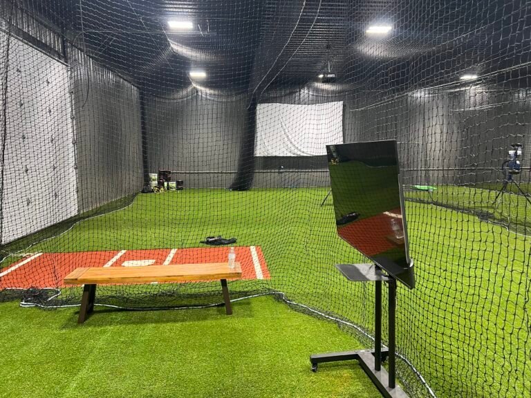 Hitting lane with turf, netting, and a monitor at Turf Monsters